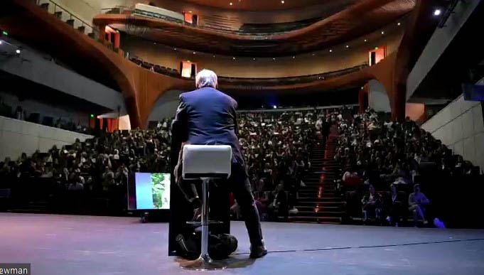 Conferencista frente al auditorio lleno de la Universidad Anáhuac visto desde el escenario
