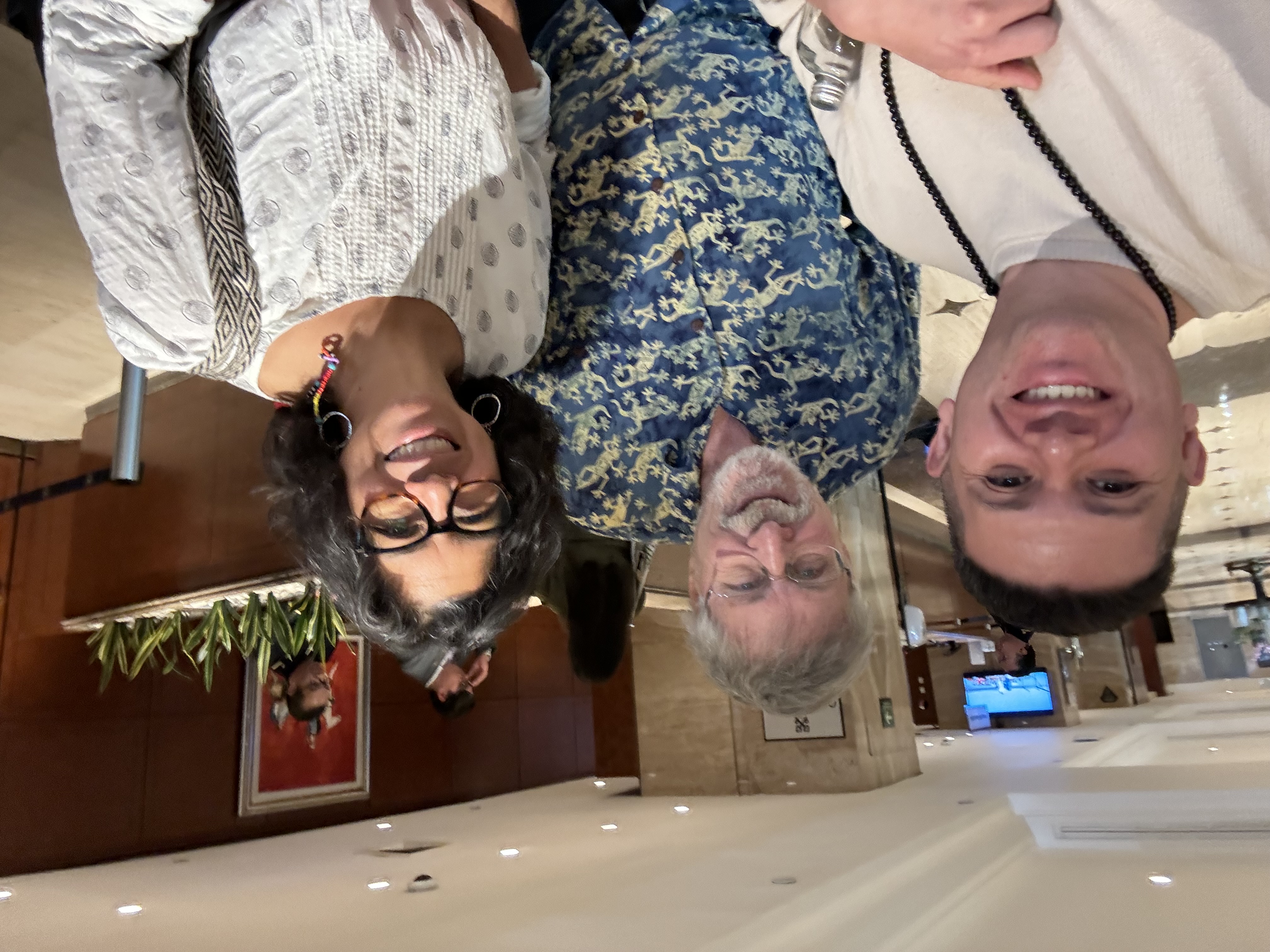 Oscar Rivas en una selfie junto a dos colegas internacionales en el lobby de un hotel